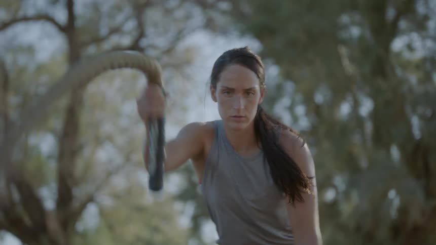 A woman bouncing ropes off the ground