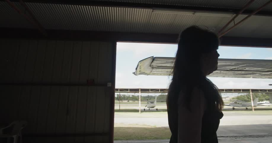 A woman runs her hand across the wing of a plane
