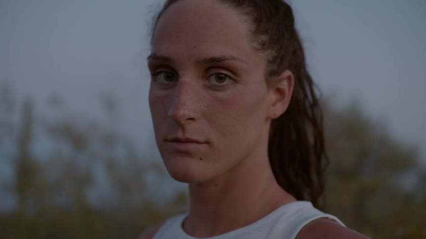 A woman stares into the camera