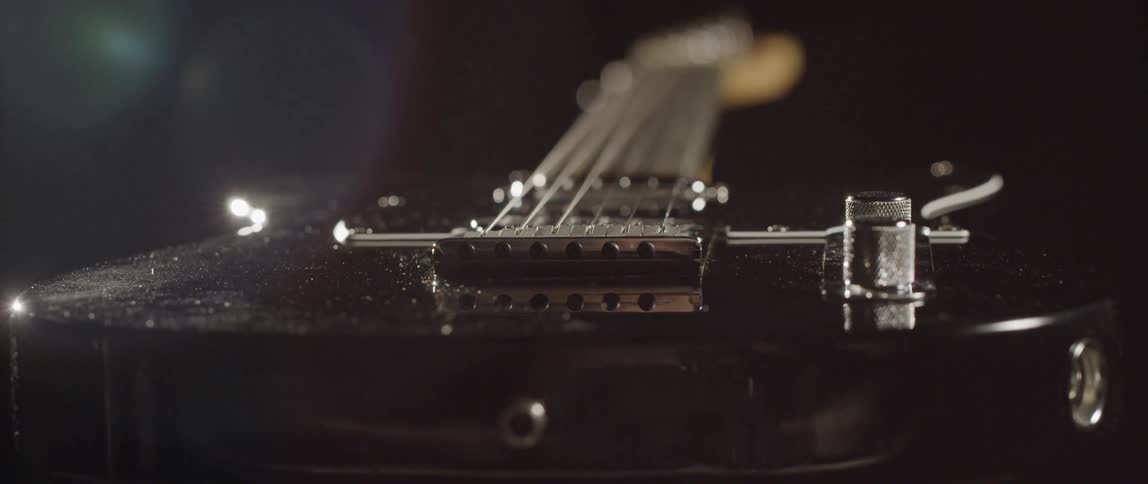 Close up of front view of electric guitar and knobs