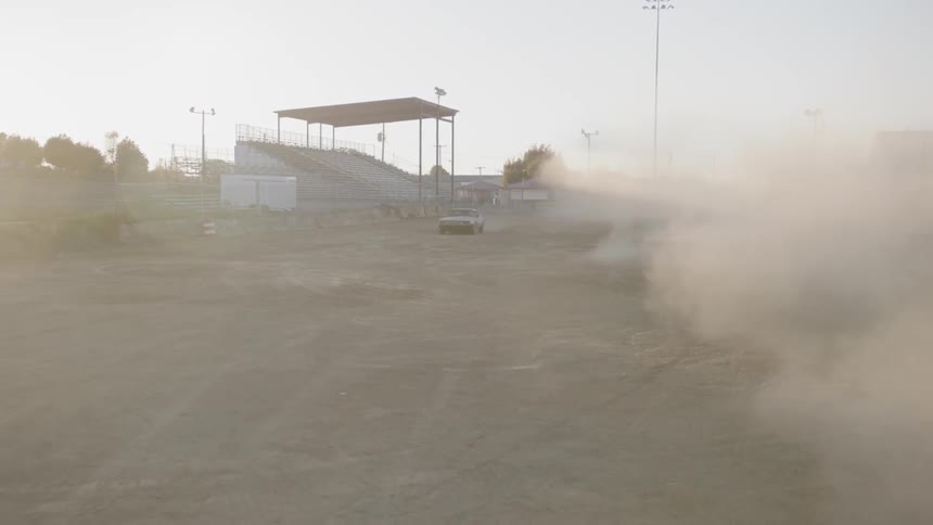 A car drives down a dust track