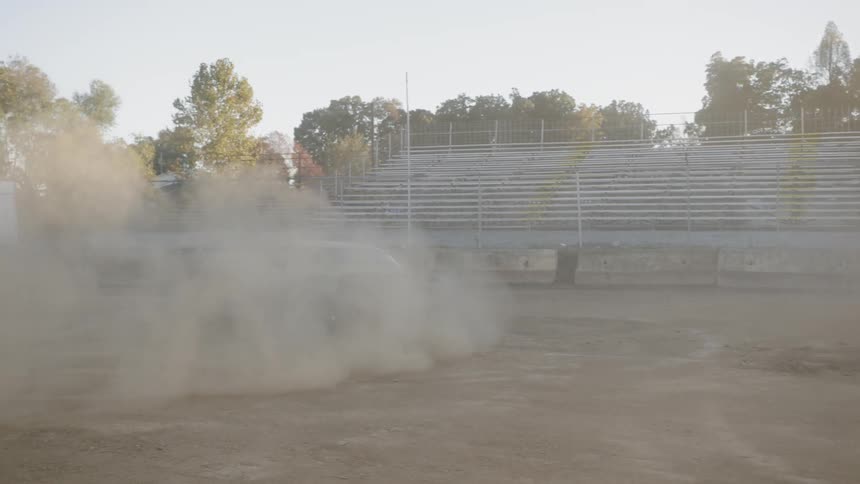 Dust kicks up as a car spins around in a dirt field