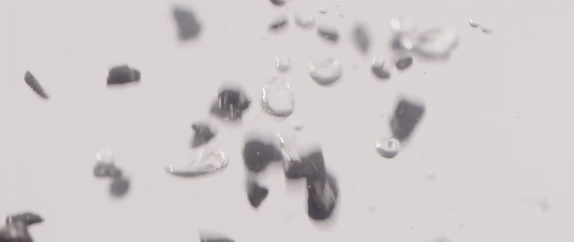 Flakes fall through water as bubbles rise up