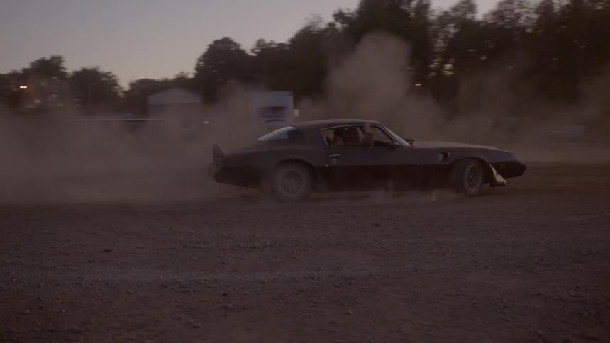 A vehicle is doing doughnuts in the dirt field