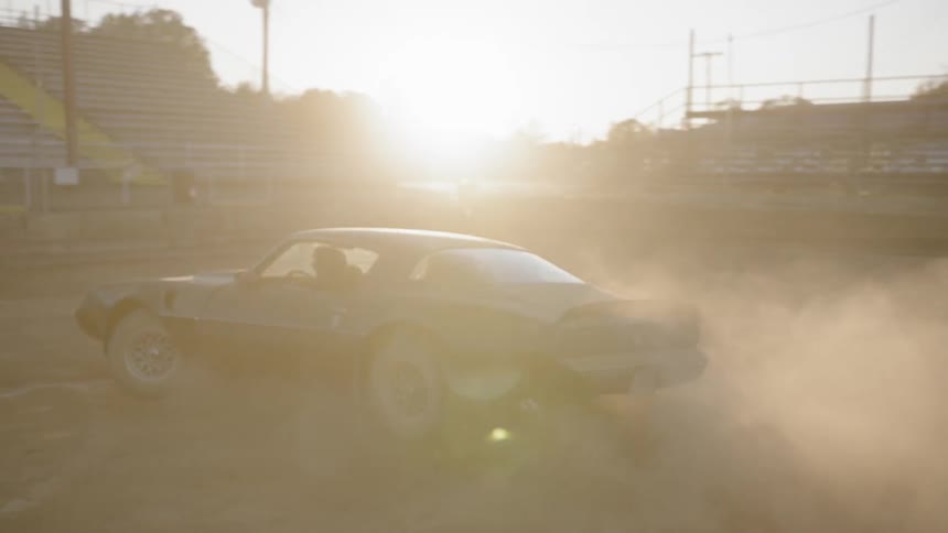 A car driving around a dirt arena