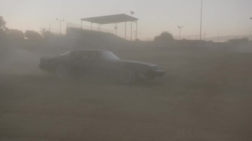 A car driving around on a dirt field