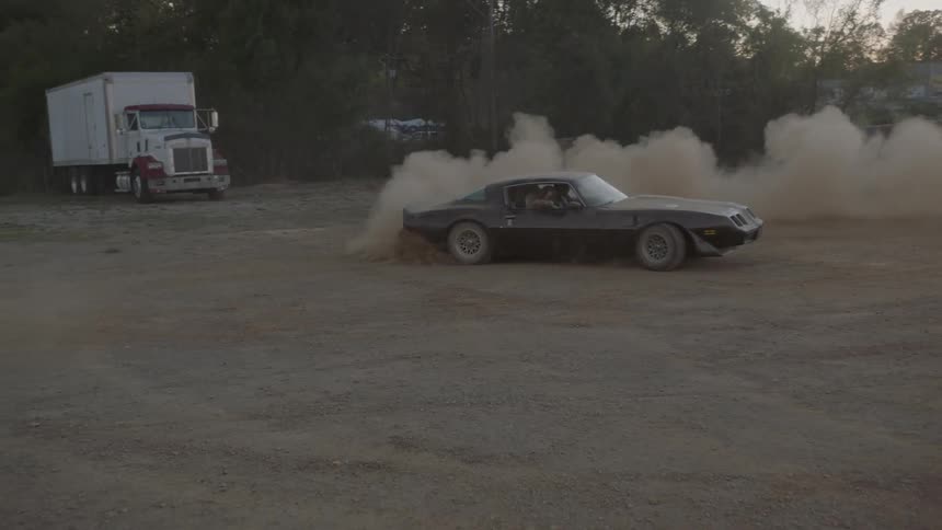 A car drives aggressively in a dirt arena