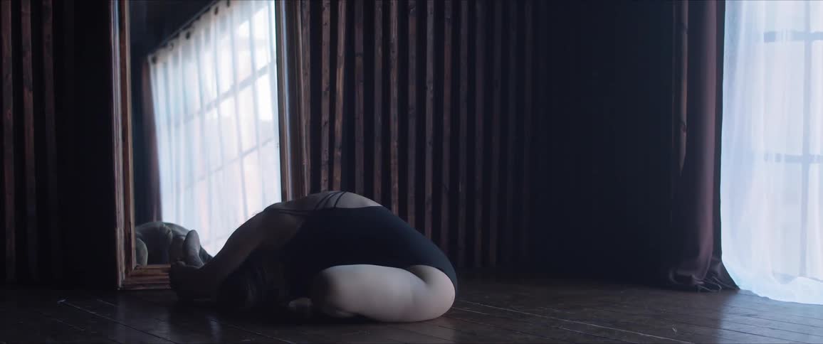 A woman stretches in front of the mirror