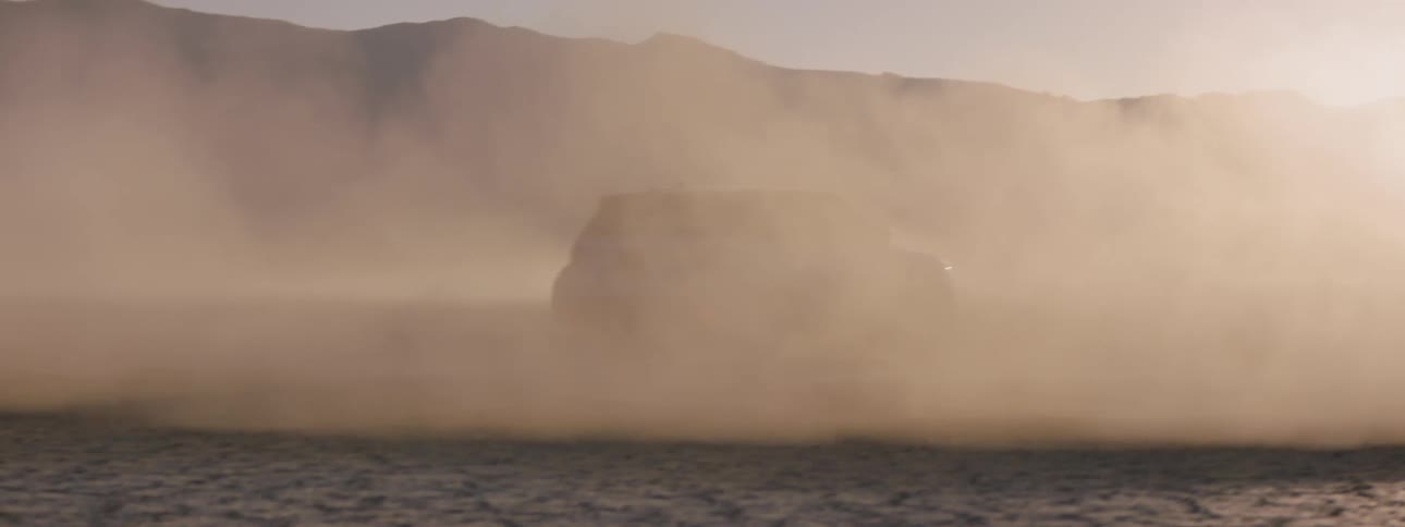 Drivers create dust clouds in the desert by driving in circles with sharp turns