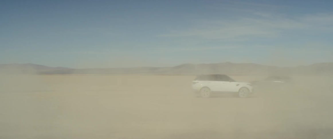 Vehicles doing donuts in the desert creating dust
