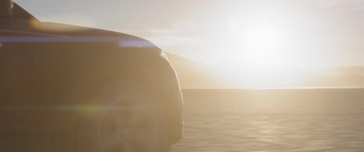 A vehicle drives down the desert