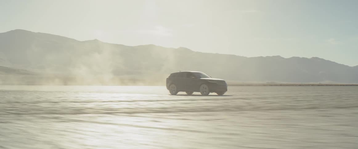A black range rover sport speeds across the salt flats