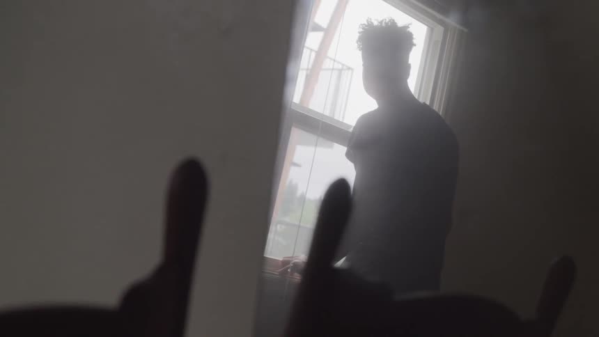Man stands looking out window