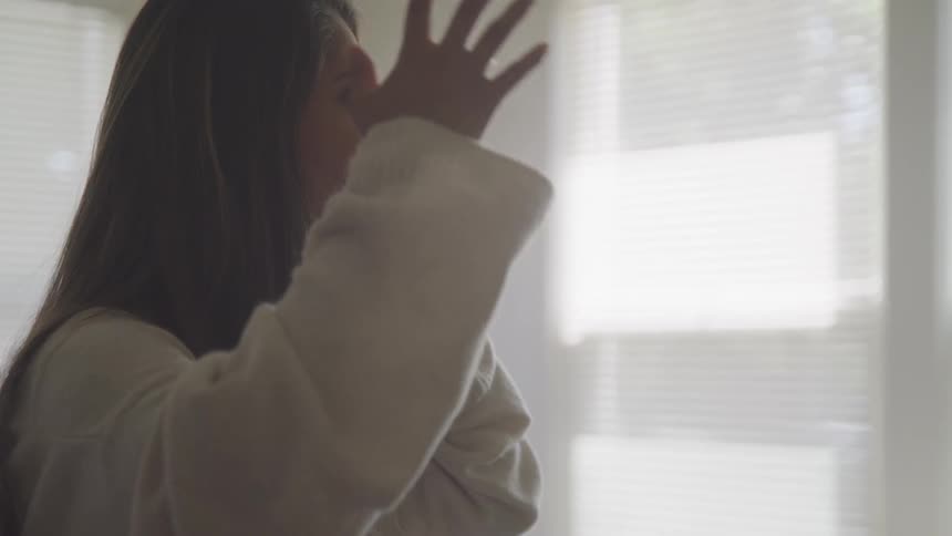 A teenager yells and throws her arm in the air while on the phone