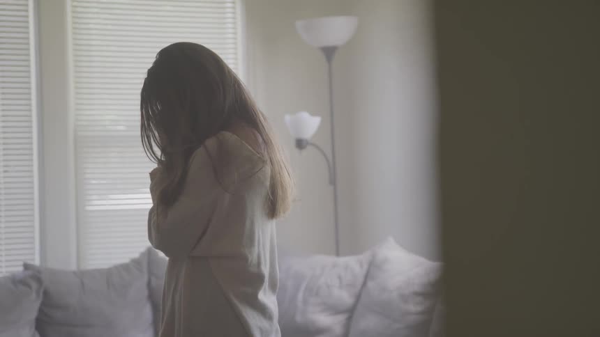 A woman standing in a living room at daytime