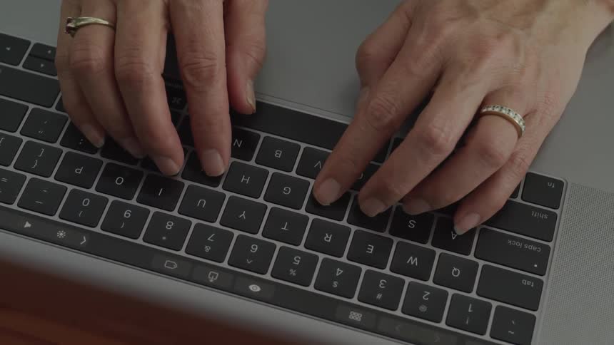 Female types on the keyboard of a laptop computer