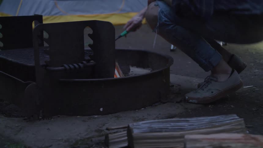 A person lighting a campfire