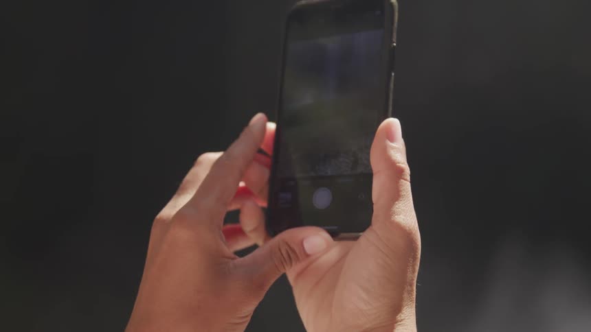 Hand holding a cell phone then raising up to take a selfie