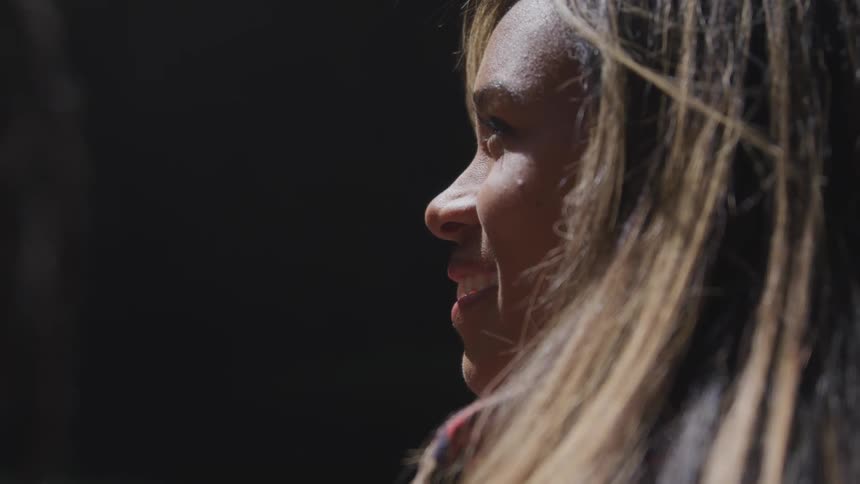 Light shines on a smiling womans face