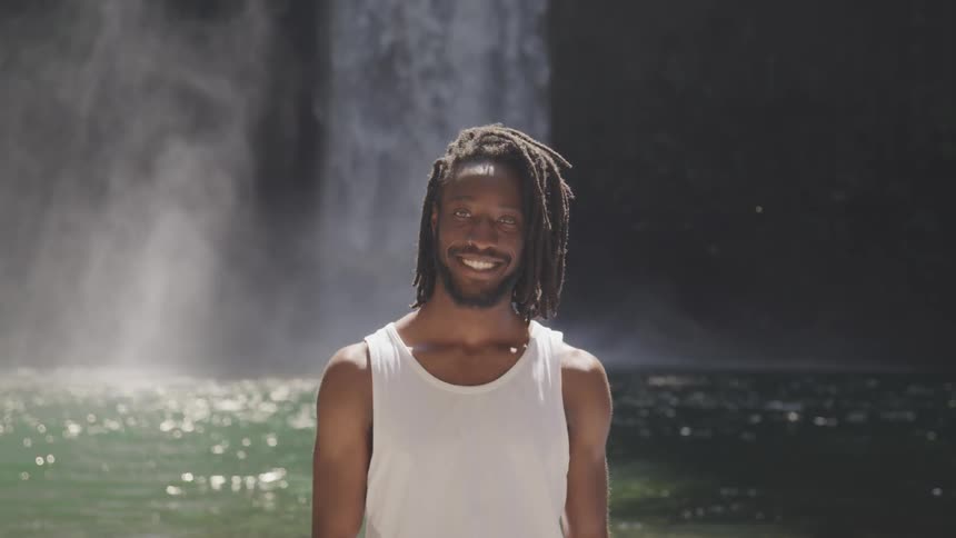 A black man portrait in front of waterfall