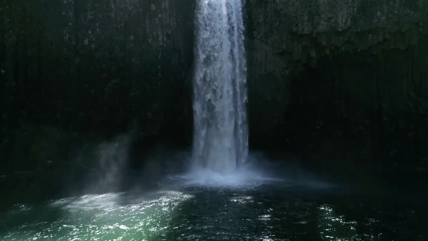 A waterfall with the sun reflecting off the water