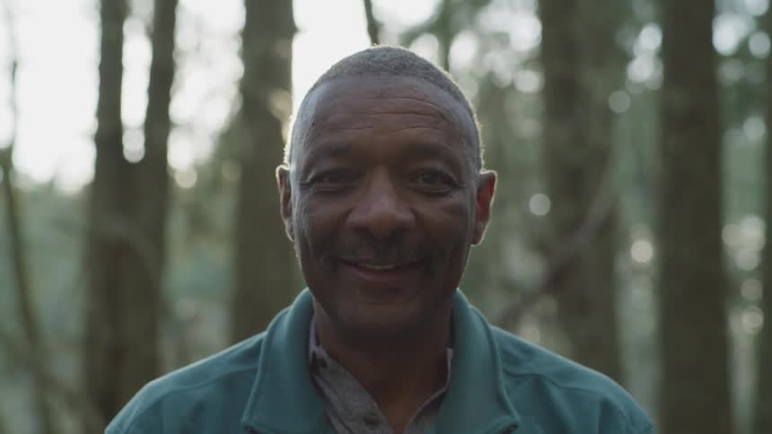 Man looks up smiling while standing outdoors
