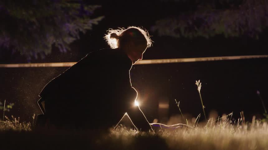 Female investigating at a crime scene outdoors at night
