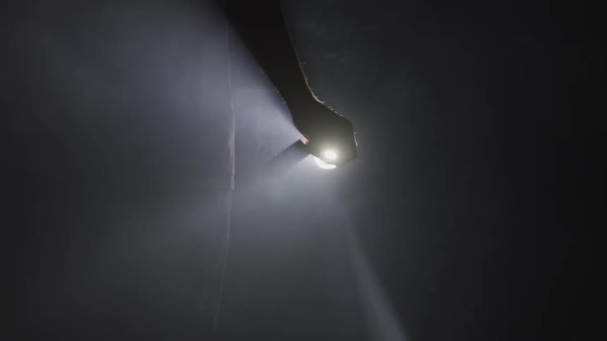 Man holding a knife in the dark