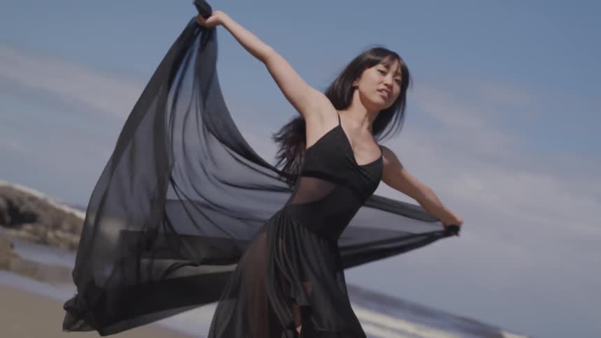 A woman dances on the beach