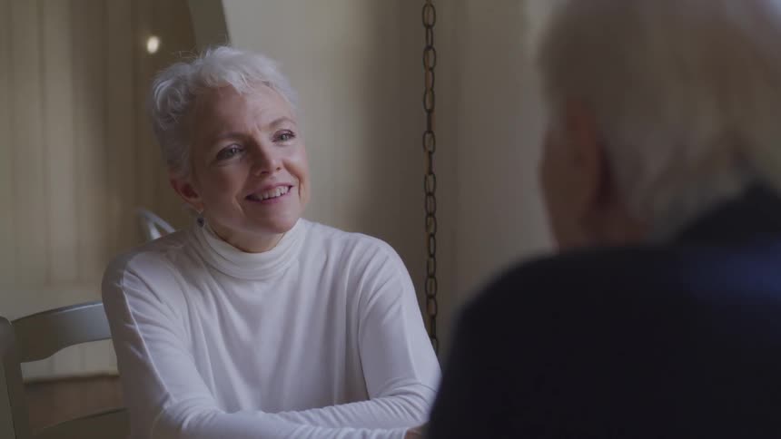 Elderly couple sitting at home talking to each other