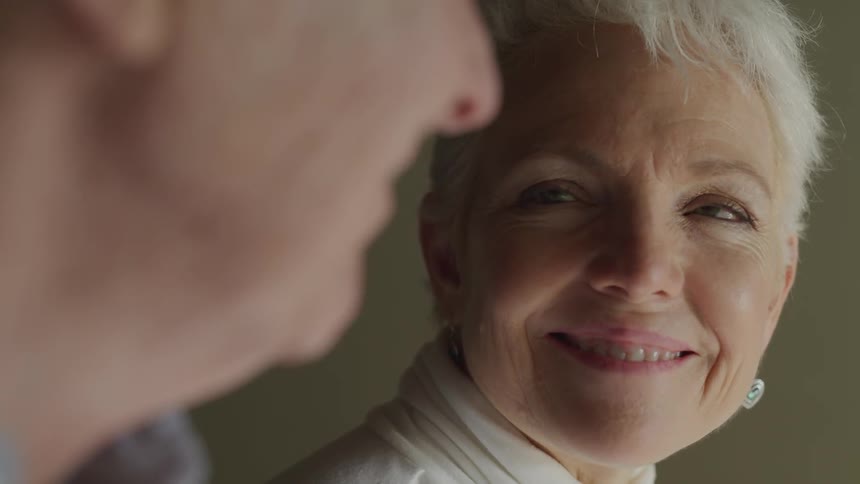 Female blinks as she gazes into the eyes of a male with love and adoration