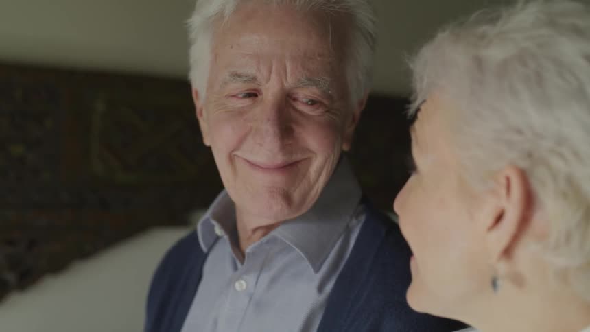 An older couple smile at one another