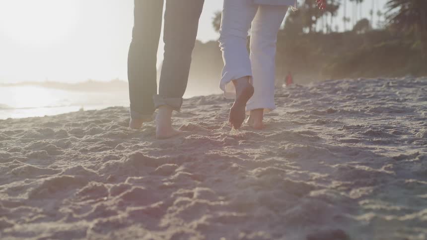 A couple walk along a beach together