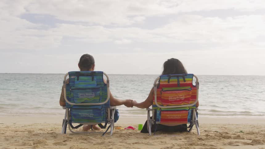 A man and woman holding hands at a beach