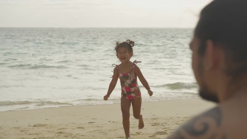 A child running to her parents on the beach