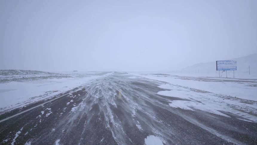 Snow blowing over a highway road