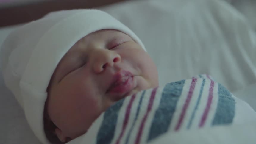 A sleeping baby sticks his tongue out