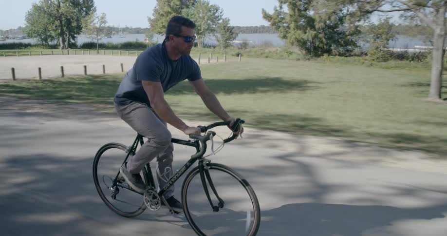 A man bikes quickly down the road