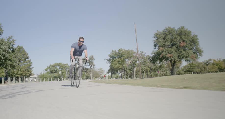 A man rides his bike on a path