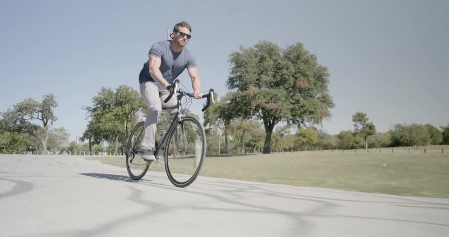 A man speeding down a road on a bicycle