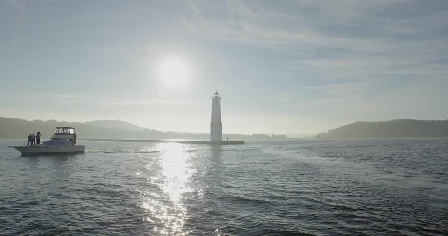 A boat moves away from the lighthouse
