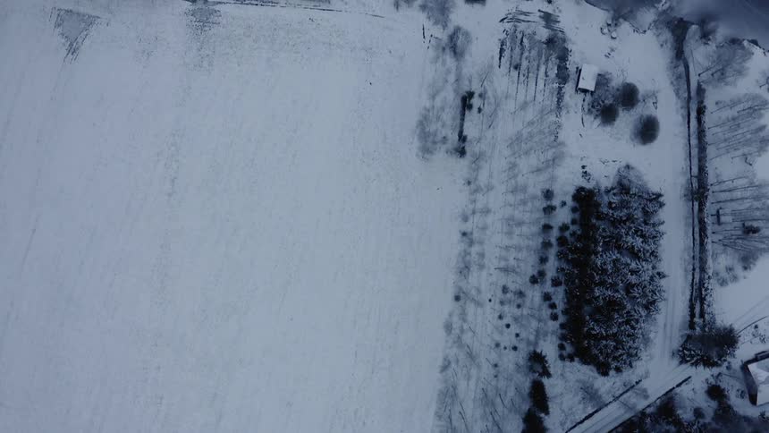 A road snakes through a snow covered rural area