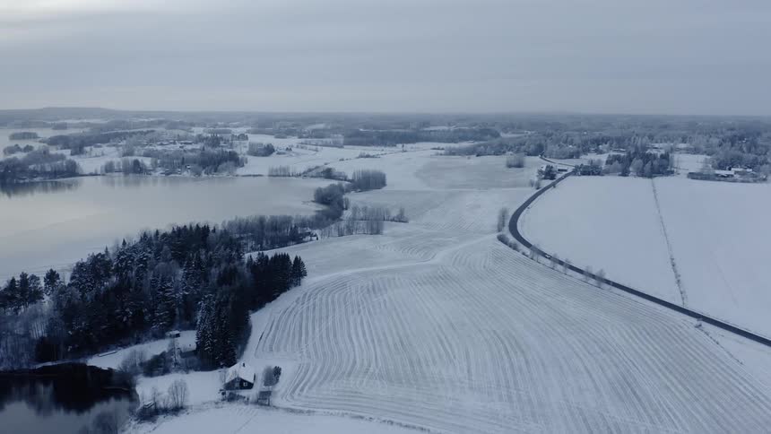 Passing over snow covered farm fields with rows defined