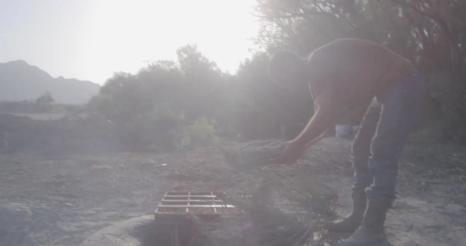 A man putting twigs into a hole filled with water