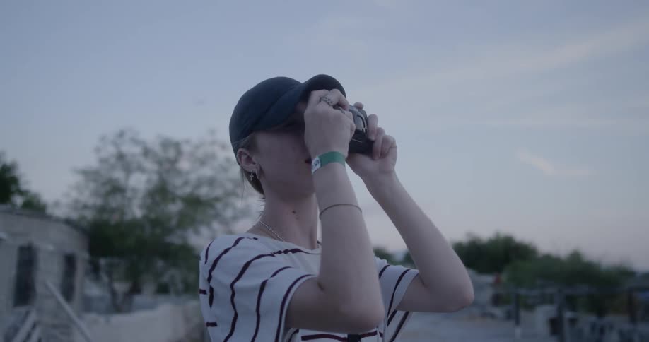 A woman holds a camera to her face to take a picture