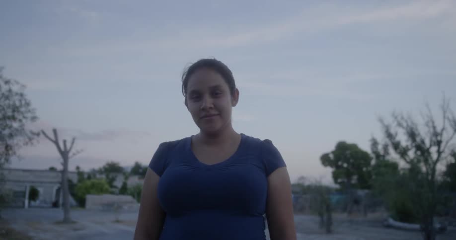 A teenager girls stands in a rural area