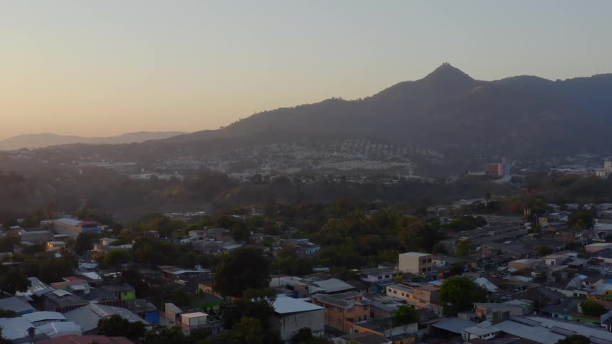 Flying over a city with hills in the background