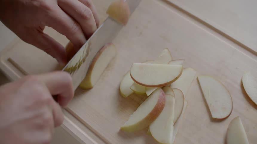 A person is cutting an apple with a knife
