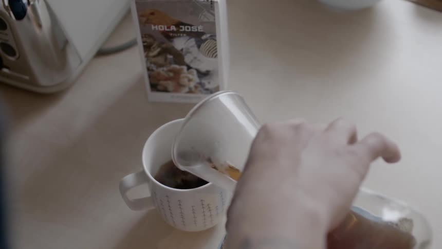 A hand pouring coffee to a glass