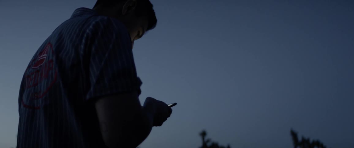 A man uses a phone outside at night